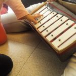 una bambina mentre suona lo xilofono al nido in famiglia