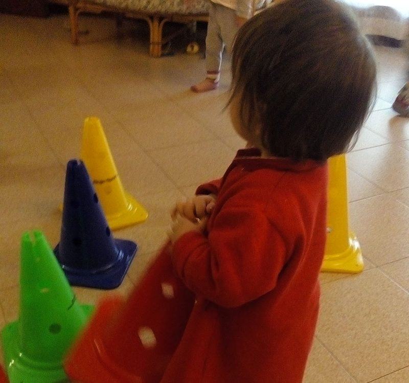 un bambino mentre gioca con i cilindri al nido in famiglia